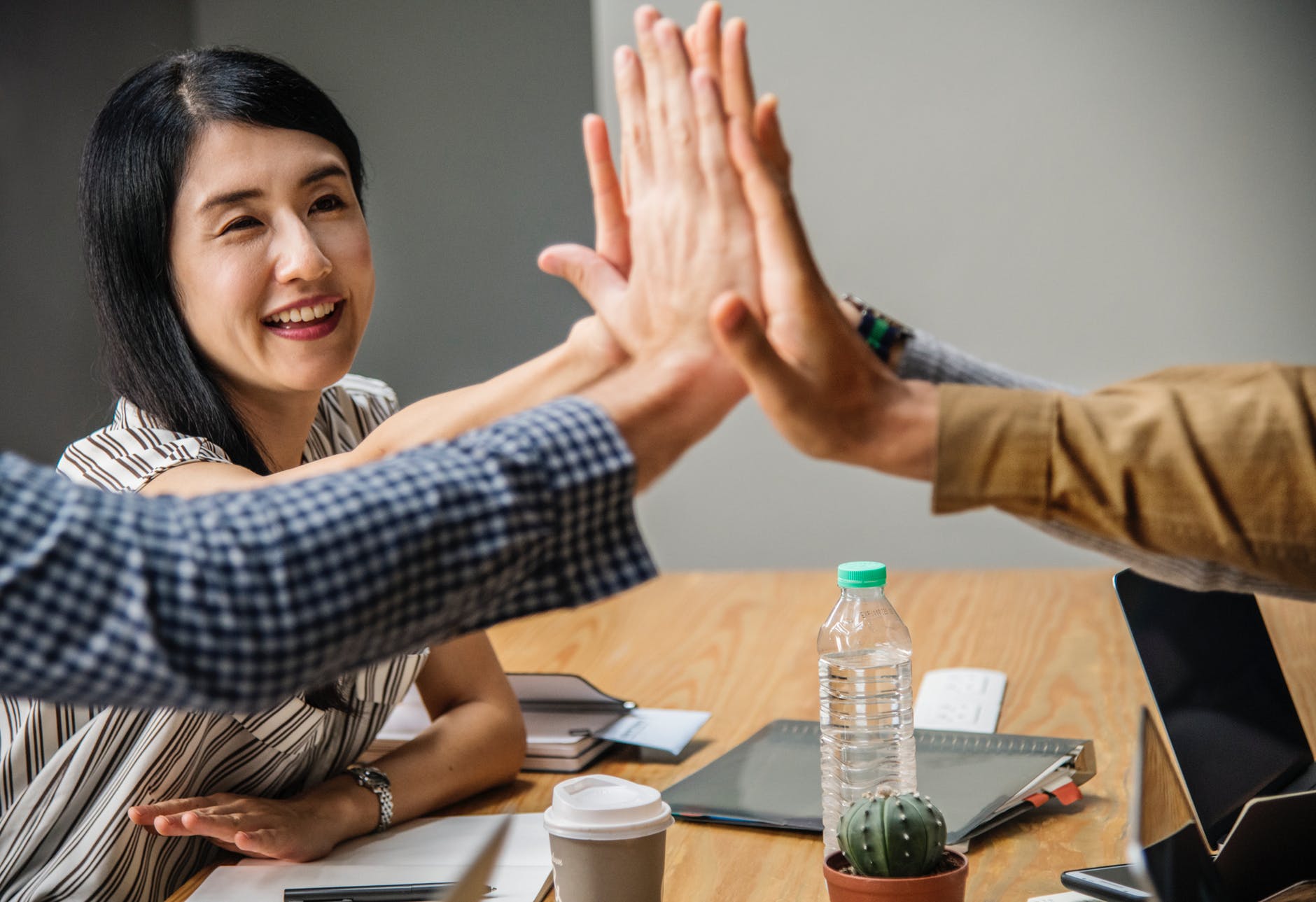 four people clapping each other